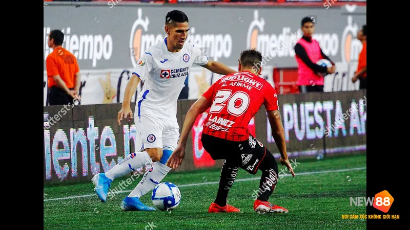 Cầu thủ của Club Tijuana dốc sức chạy để giành bóng từ cầu thủ của Cruz Azul